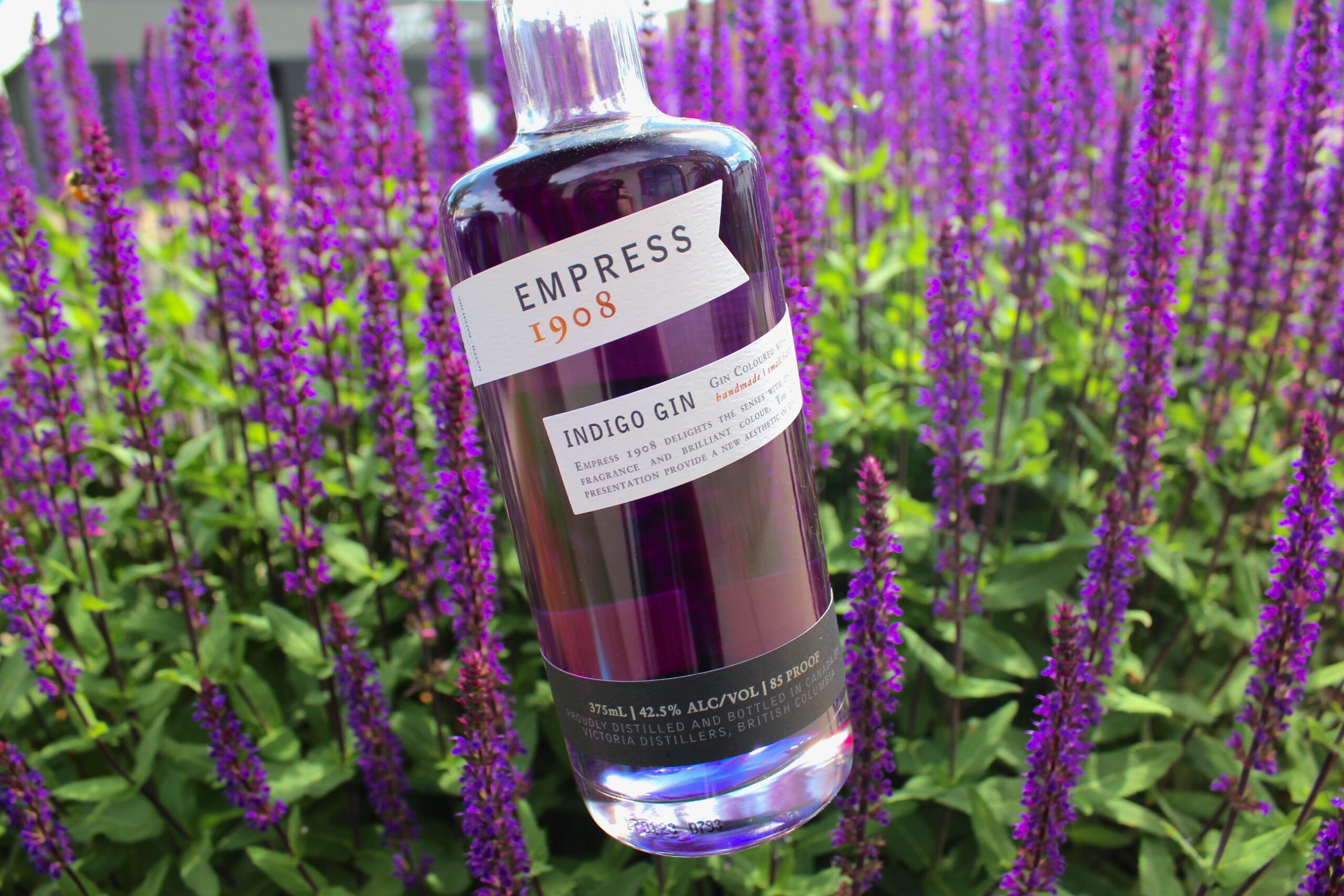 bottle of empress gin in front of purple flowers