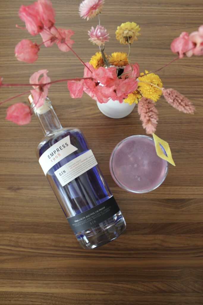 bottle of empress 1908 gin, pink cocktail, bouquet of flowers