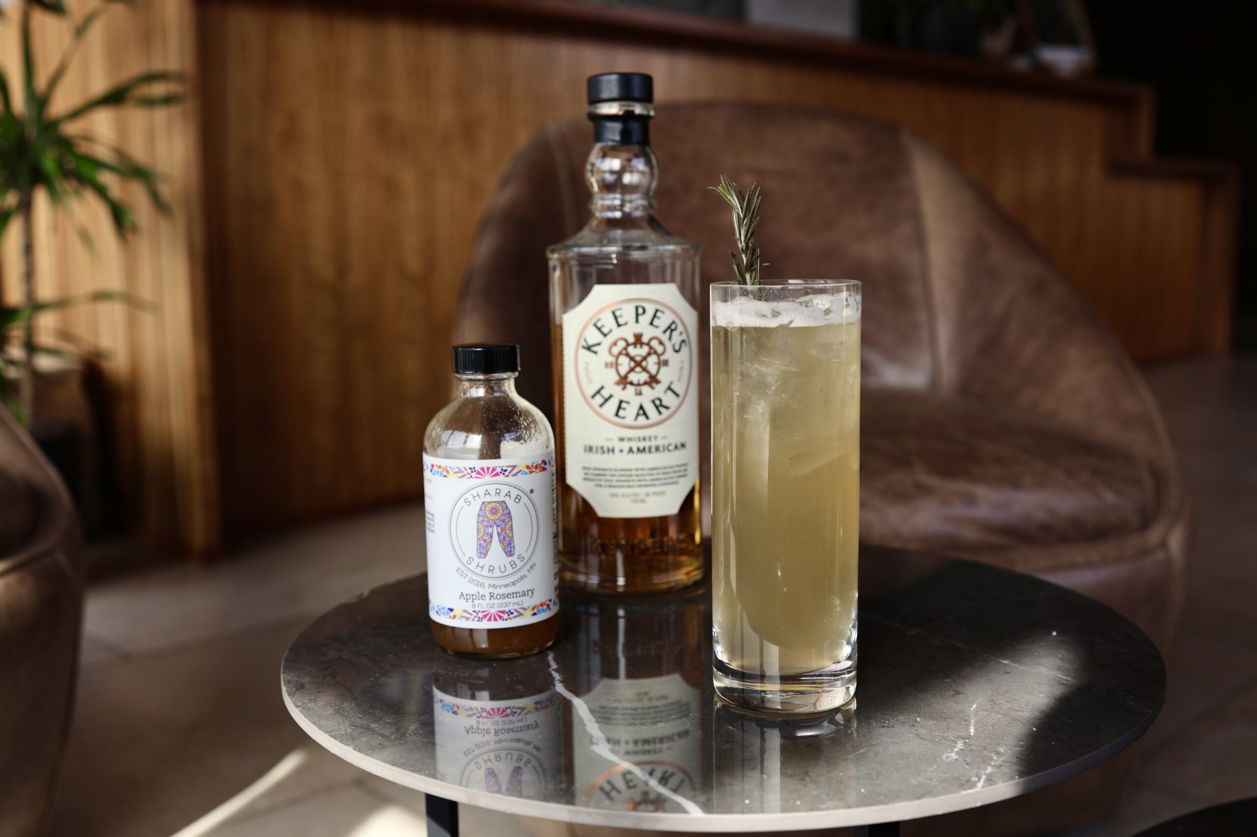 Cocktail in a highball glass sits on a coffee table