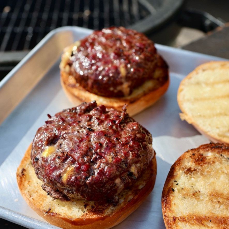 Two burgers on a metal sheetpan