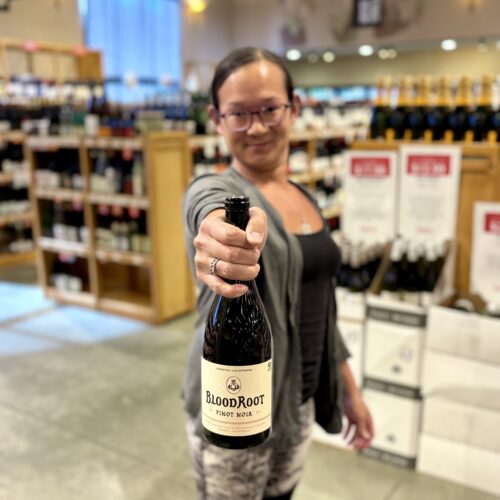TK holding a bottle of Blood Root Pinot Noir
