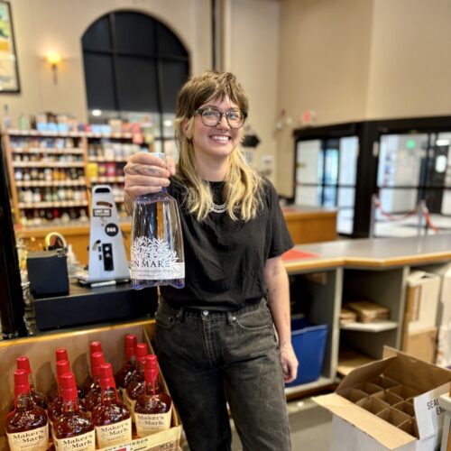 Casper holds a bottle of Gin Mare at the register