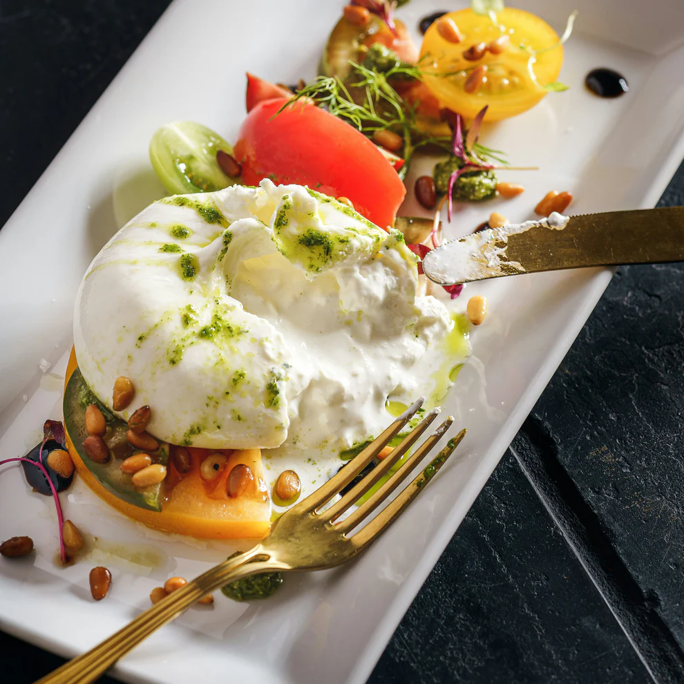 Ball of burrata over tomatoes and fresh herbs