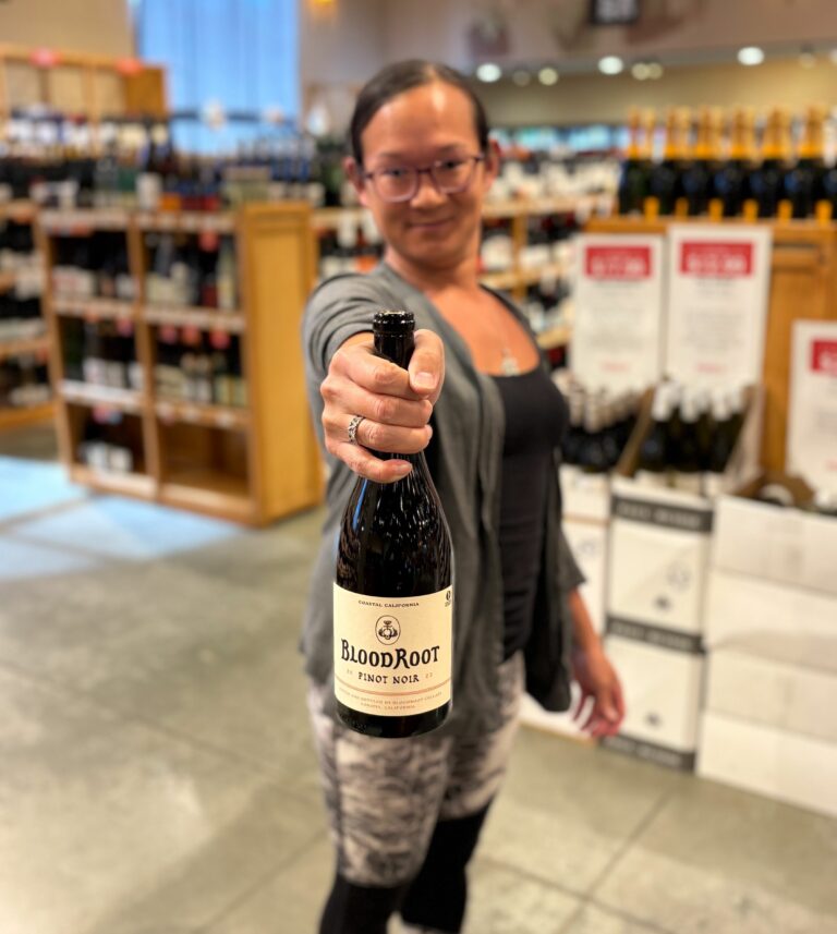 TK holding up a bottle of Blood Root Pinot Noir