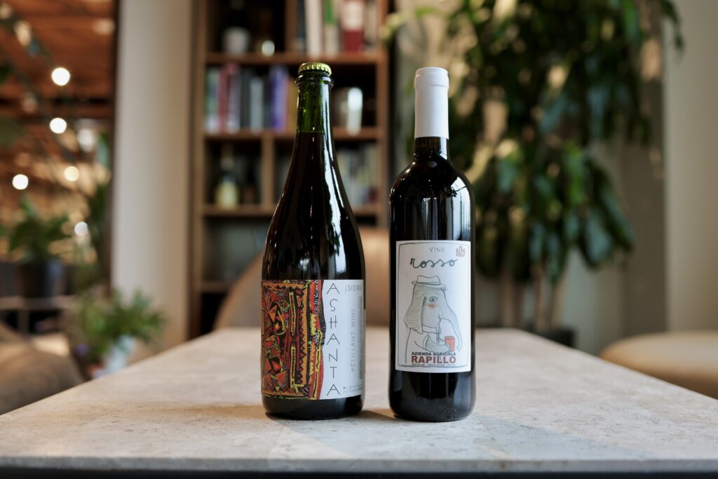2 bottles of natural wine sitting on a coffee table