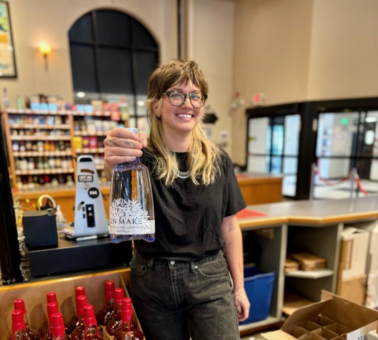 Casper holding up a bottle of Gin Mare at the register