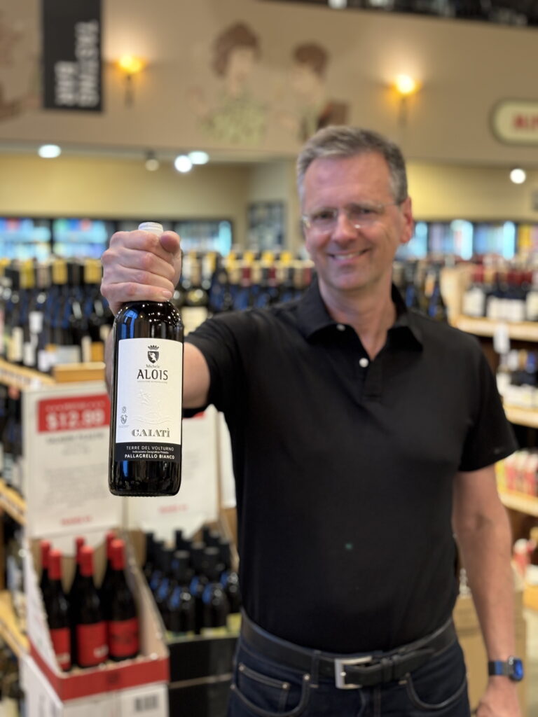 Rick holding up a bottle of Michele Alois wine