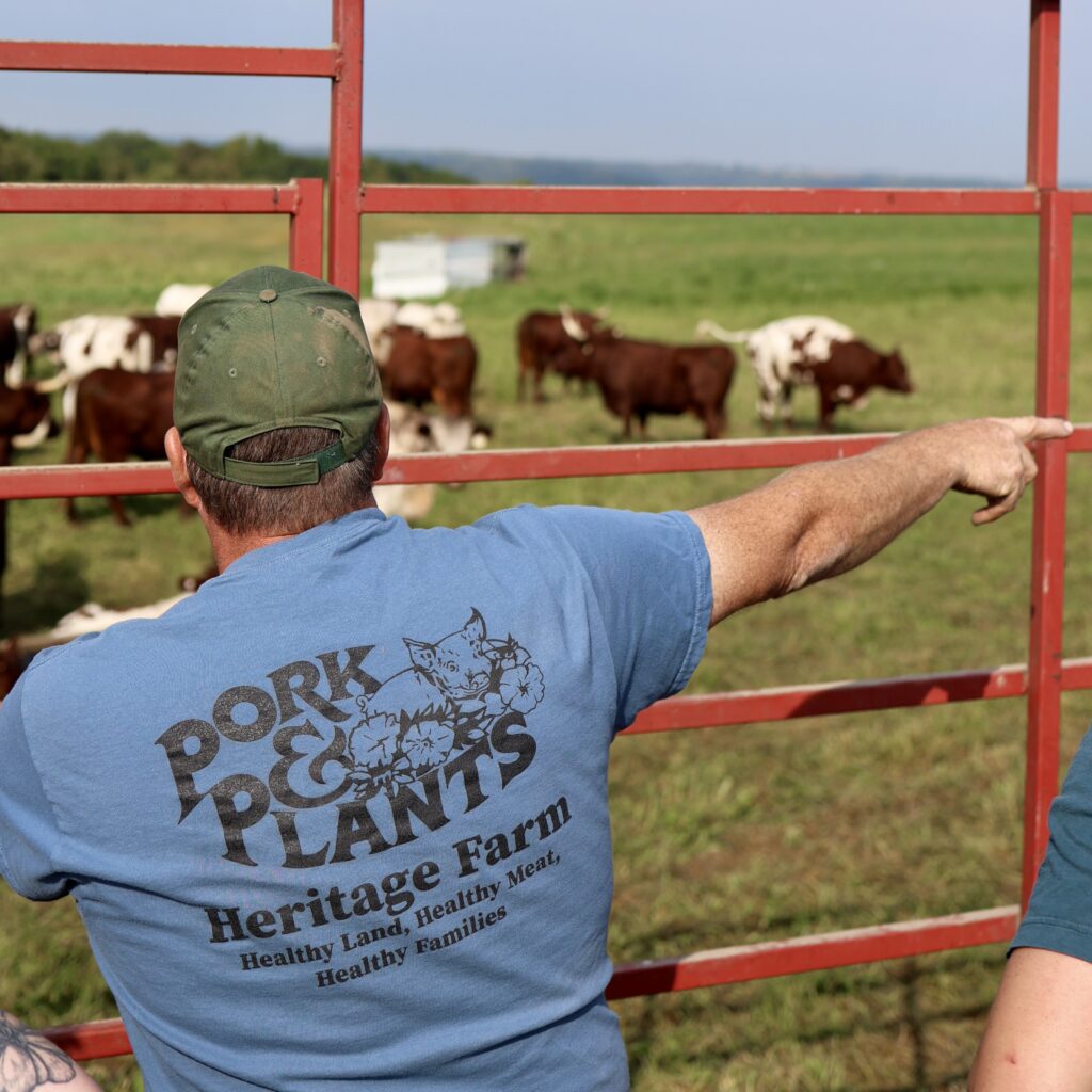 Farmer Eric Kreidermacher on a trailer pointing out at his farm