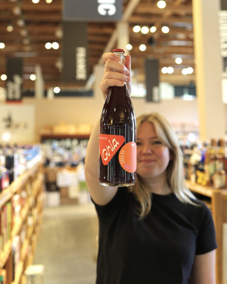 Molly holds up Le Fizz in the Non-Alcoholic aisle of the liquor store