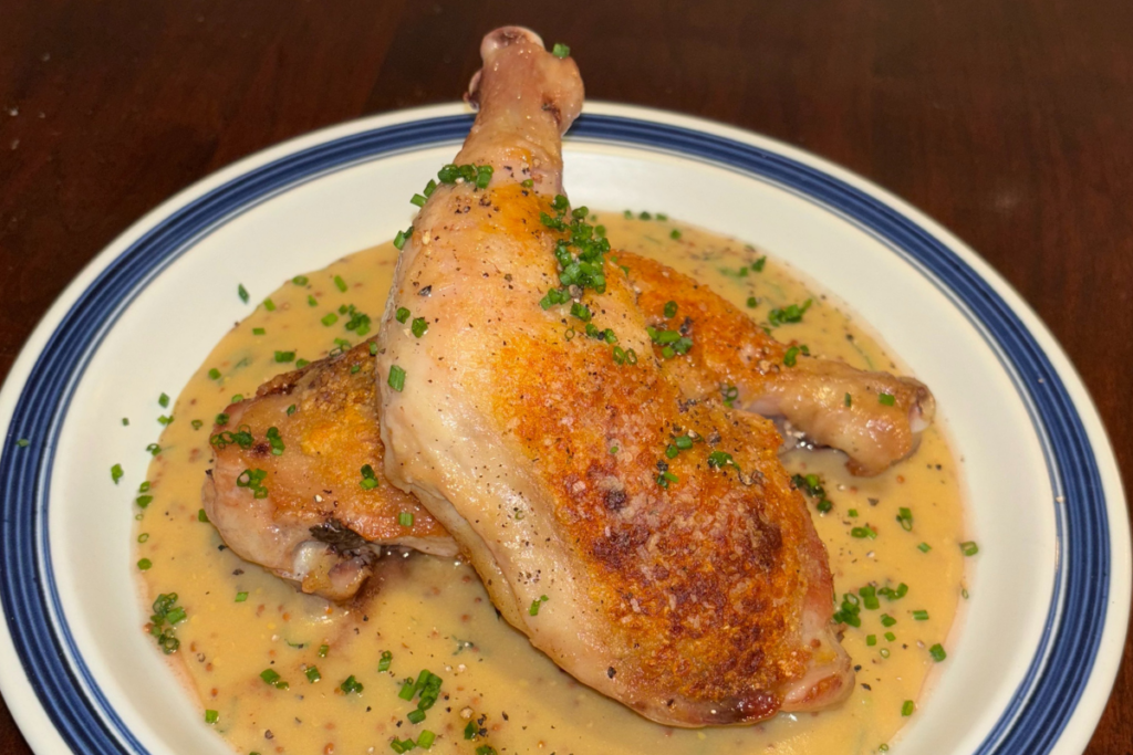 roasted mustard chicken legs on a white plate on a wooden table