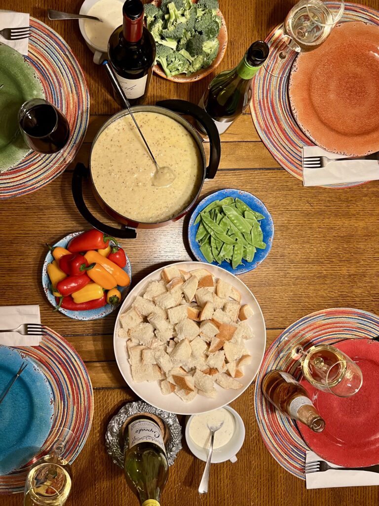 Table set with fondue, wine, and accoutrements