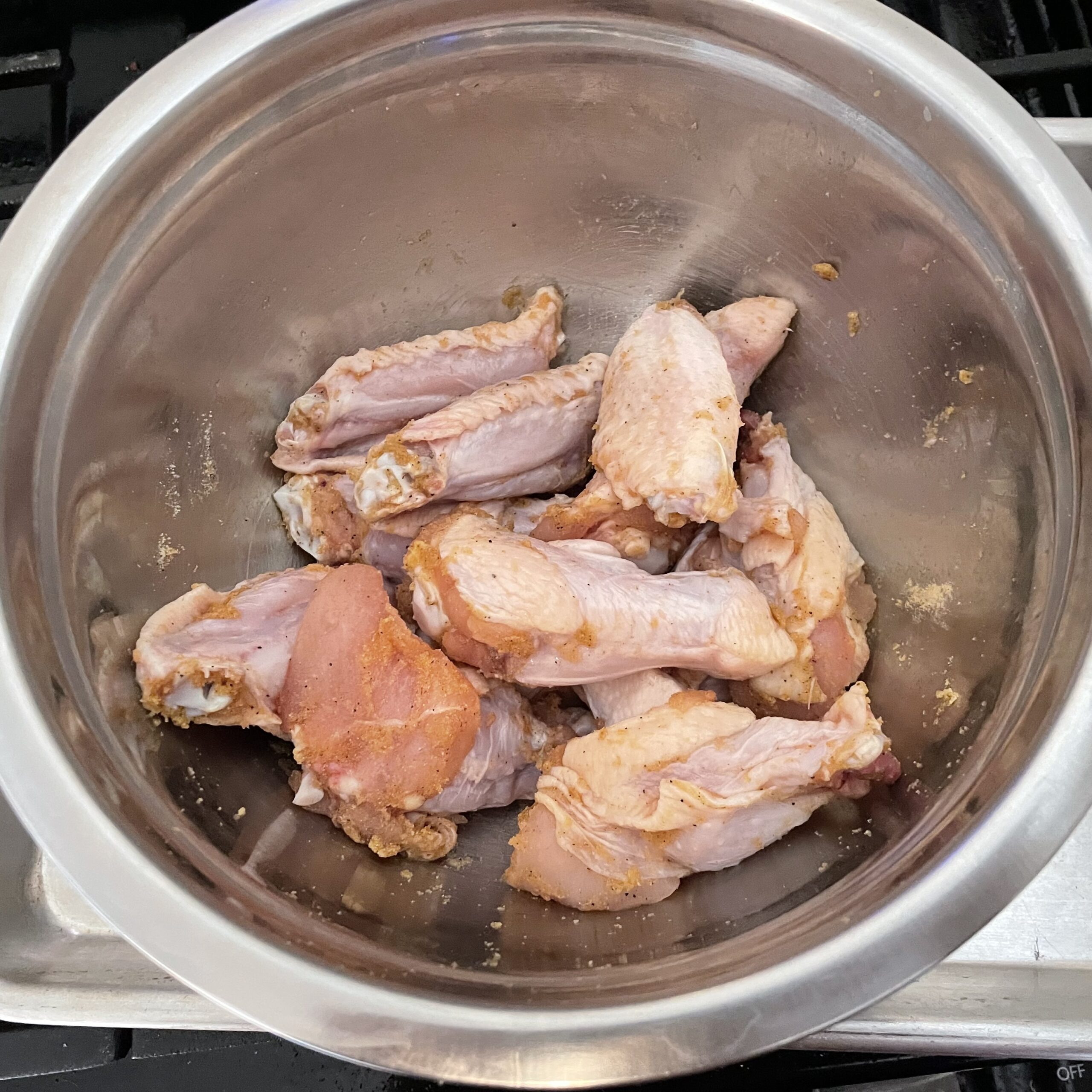 bowl of seasoned raw chicken wings