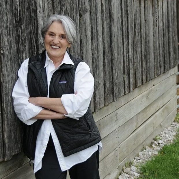 Judy Schad leaning against a wooden fence