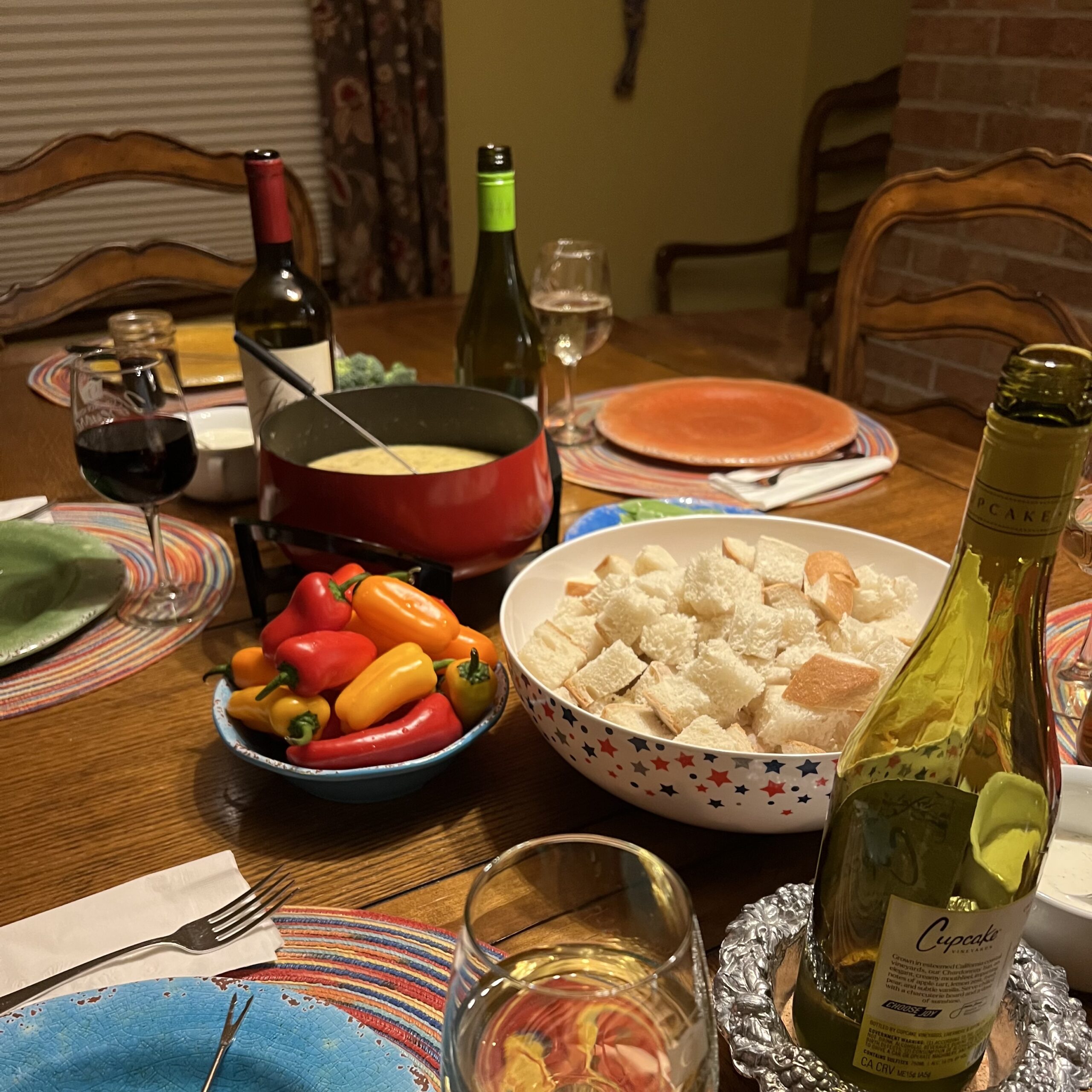 Table set with fondue, wine, and accoutrements