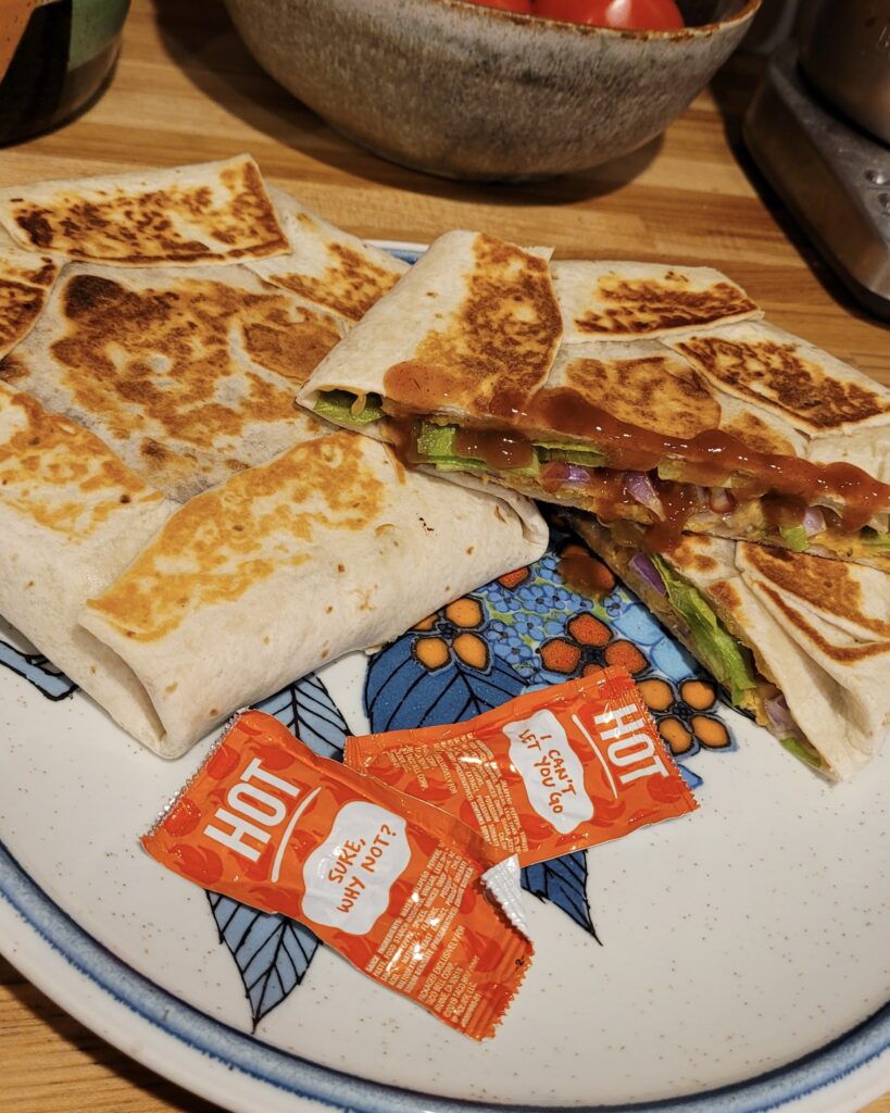 2 beany crunchfolds ona. plate with hot sauce packets