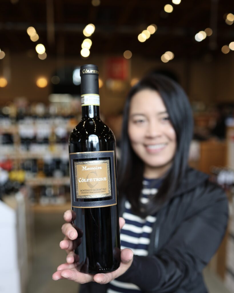 Joy holding up a bottle of Colpetrone Sagrantino di Montefalco 2015