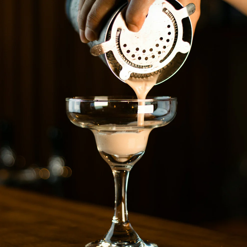 Pouring an espresso martini out of a shaker