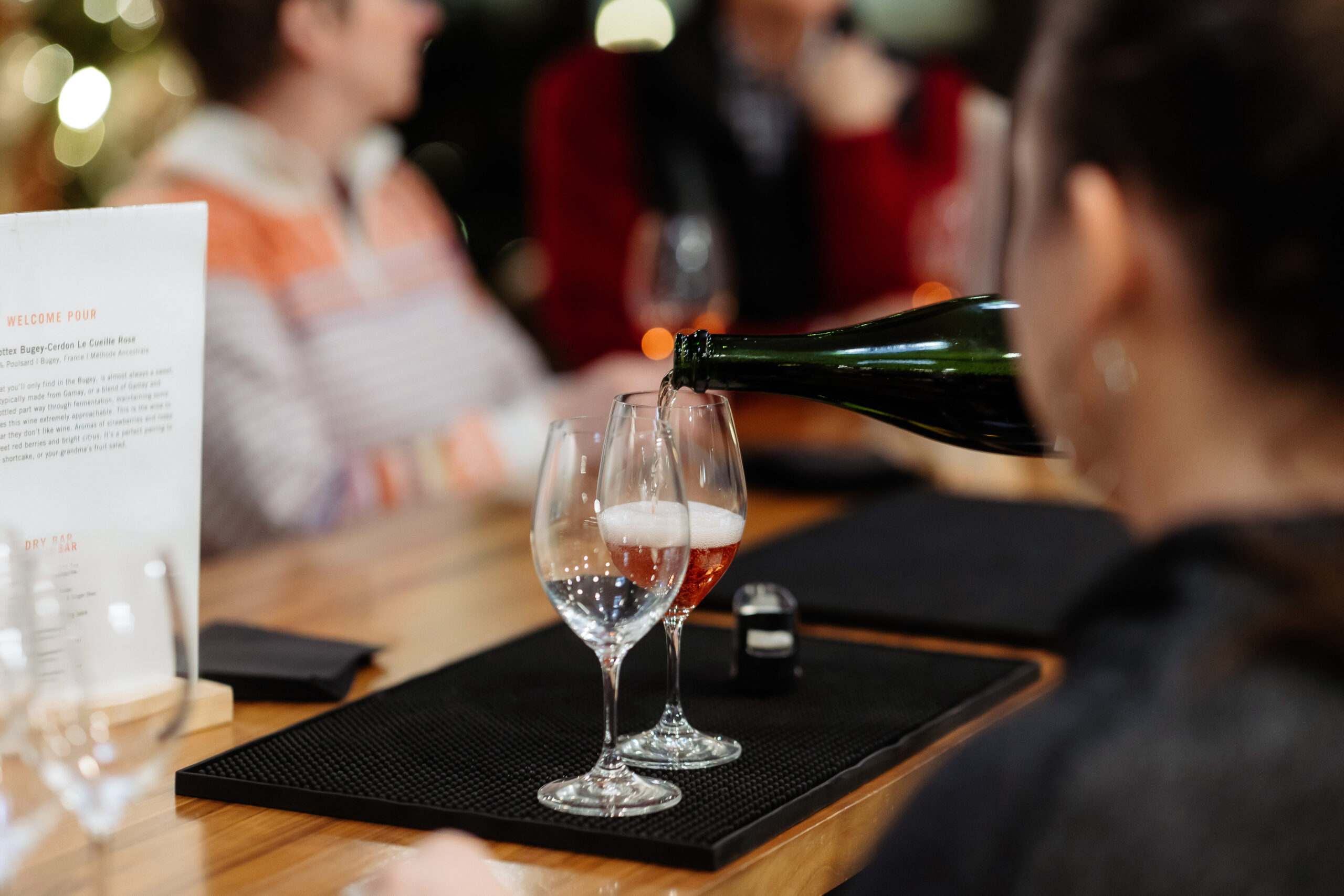 bartender fills a wine glass at the bar