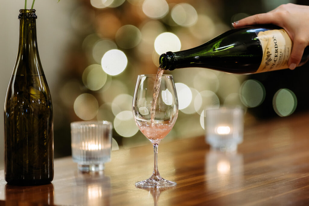 Pouring a glass of pink sparkling wine at the bar