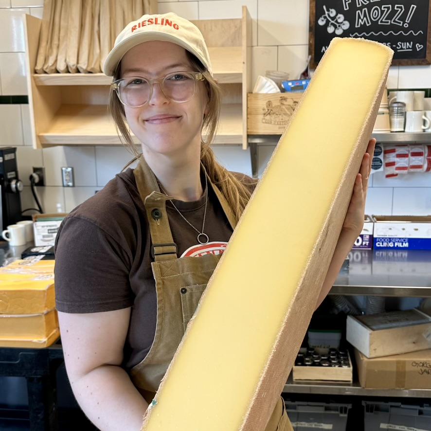 Kristin holding a wheel of Comte