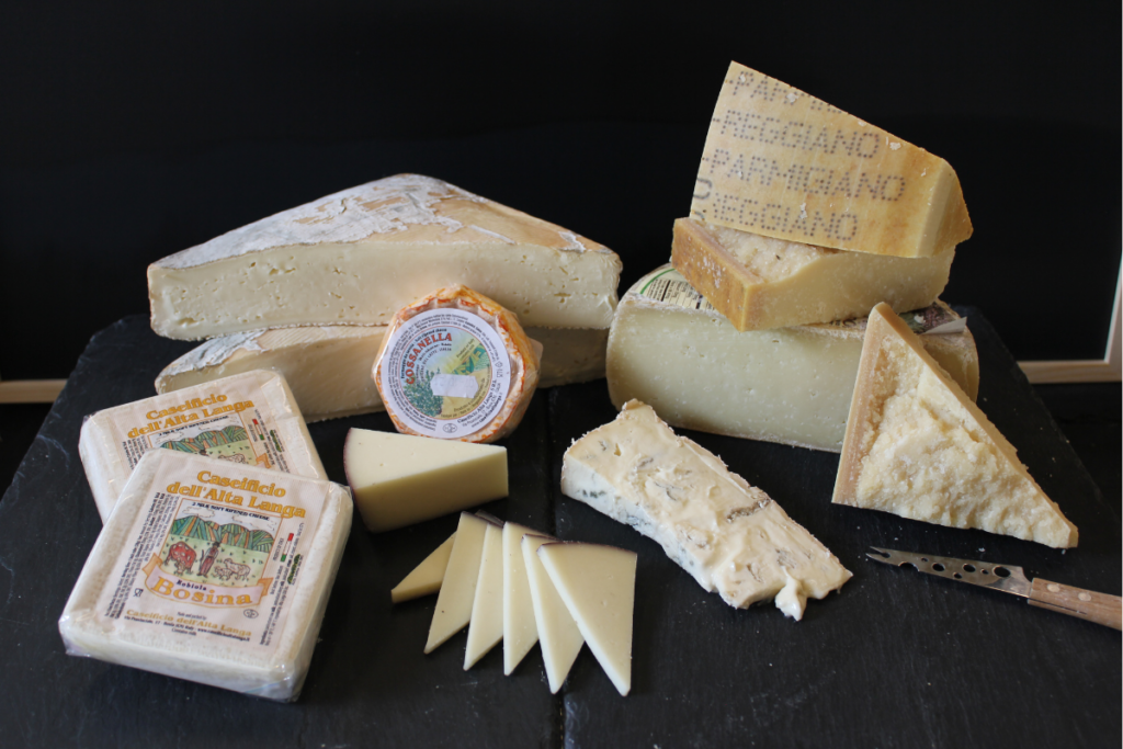 Selection of Italian cheeses on a slate in front of a black background