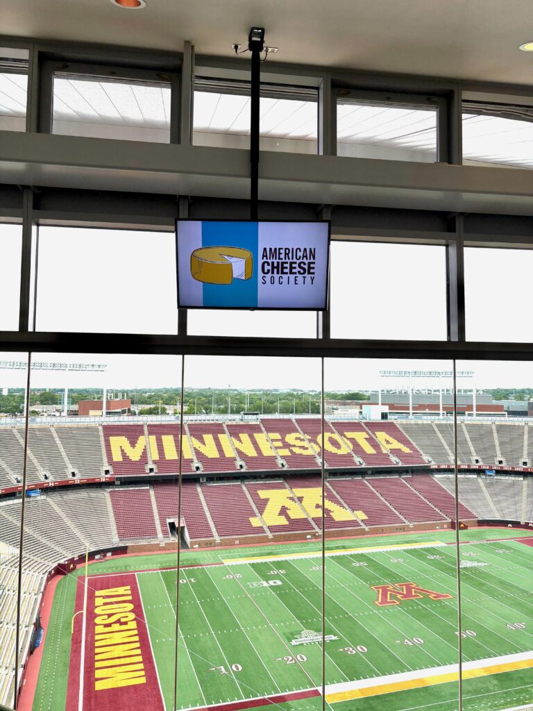 Screen with American Cheese Society Logo over the Gopher Football Stadium