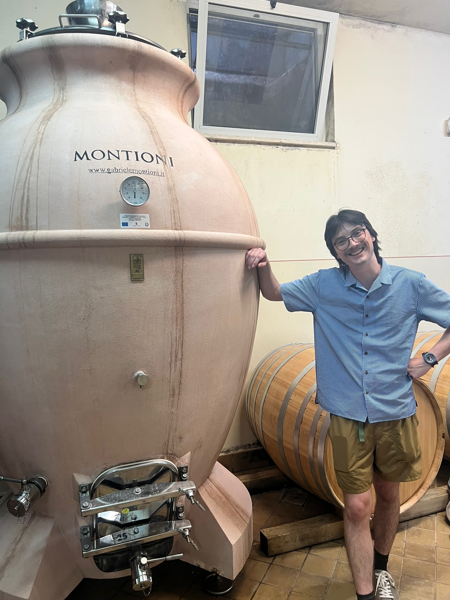 Joey next to a ceramic fermentation tank in Italy