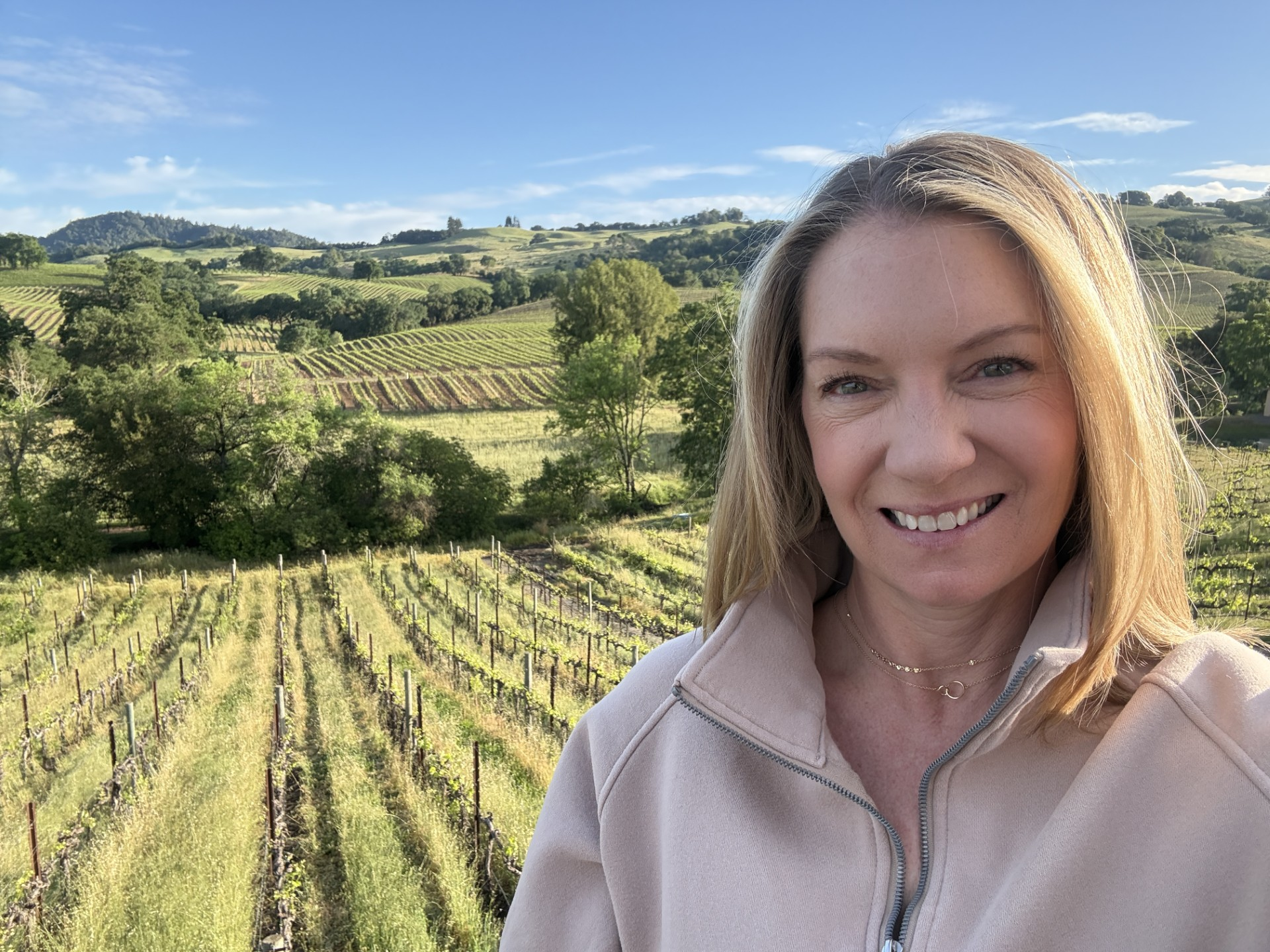 Jaclyn smiling in front of a Healdsburg vineyard