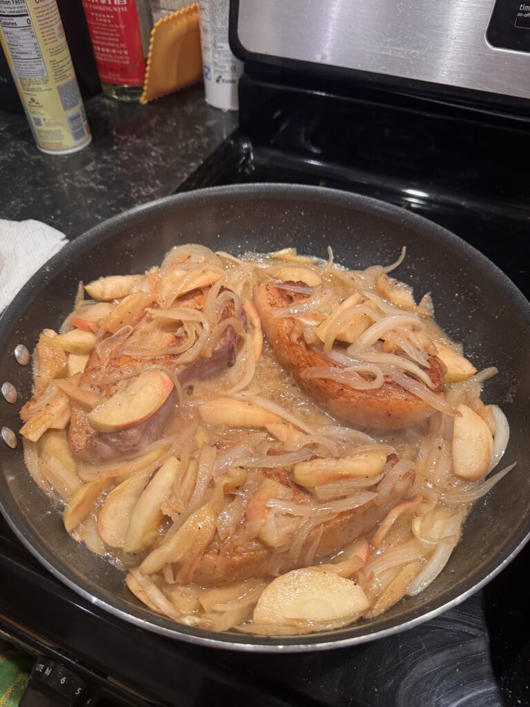 pork chops in a pan with apples and onions