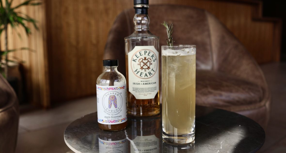 Cocktail in a highball glass sits on a coffee table